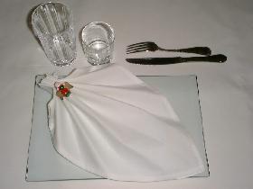 présenter la serviette sur l'assiette (ici en diagonale sur une assiette rectangulaire en verre)