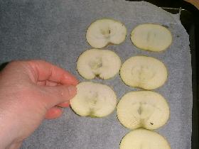 poser une feuille de papier cuisson sur la plaque du four et disposer les rondelles de pommes
