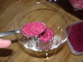 mettre 3 cuillers à café de sable rose dans le fond du verre